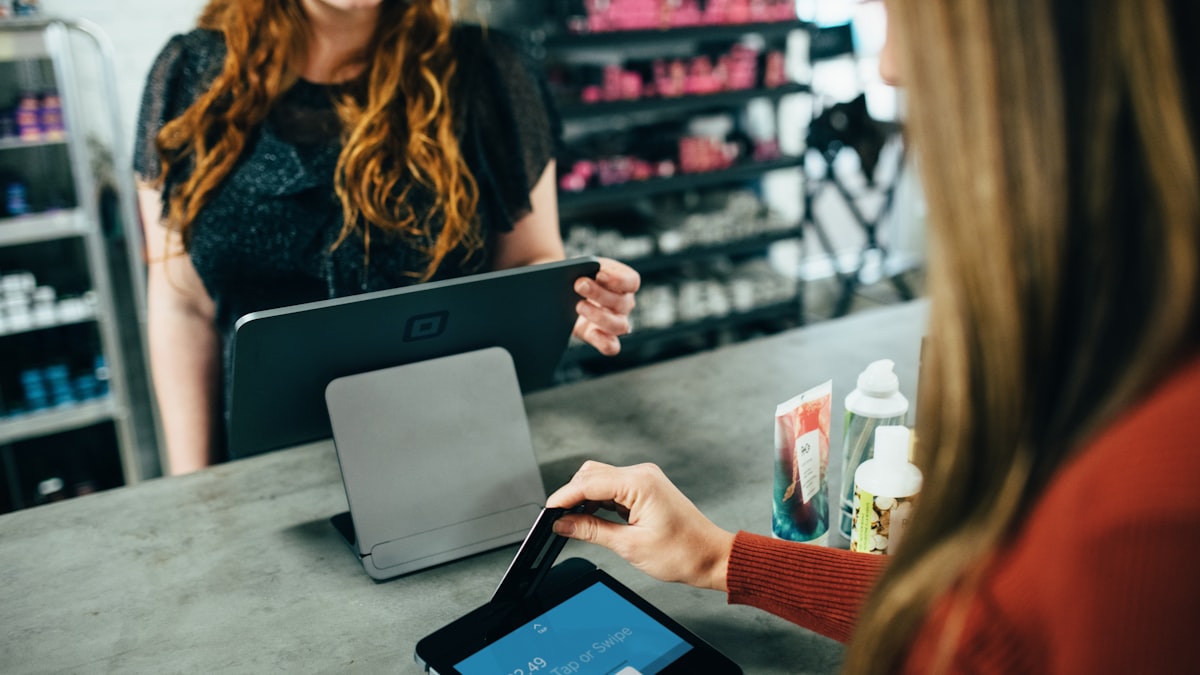 A shopper holding a payment card while browsing on a phone